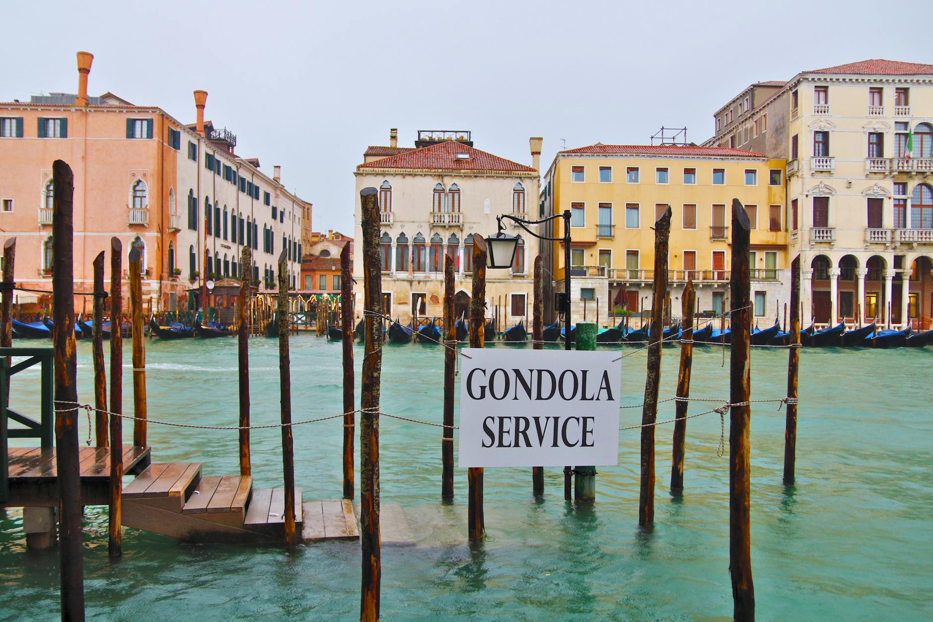 Gondola service sign on a canal in Venice, Italy, showcasing historical Venetian architecture.