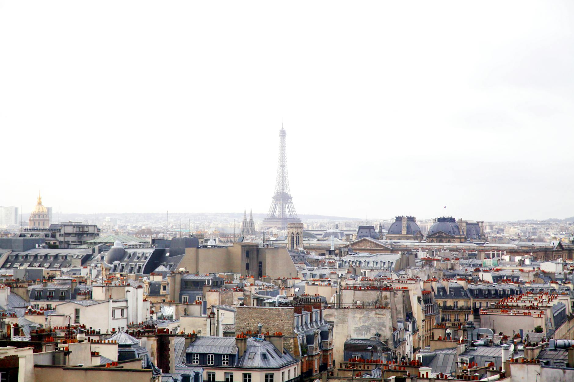 A scenic view of Paris rooftops with the Eiffel Tower in the background, capturing the city's charm.