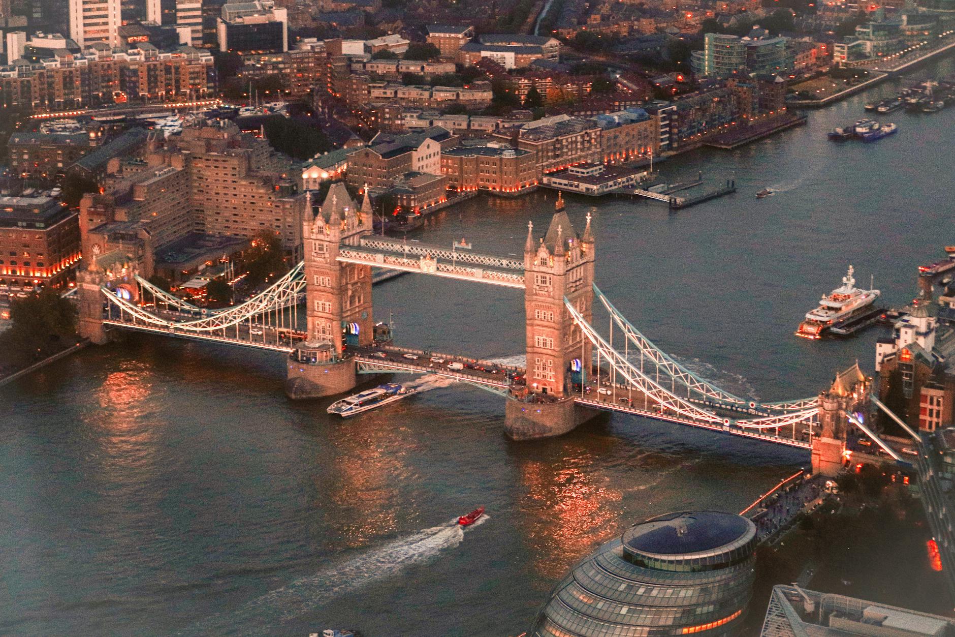 Aerial shot of iconic Tower Bridge over River Thames at sunset in London.