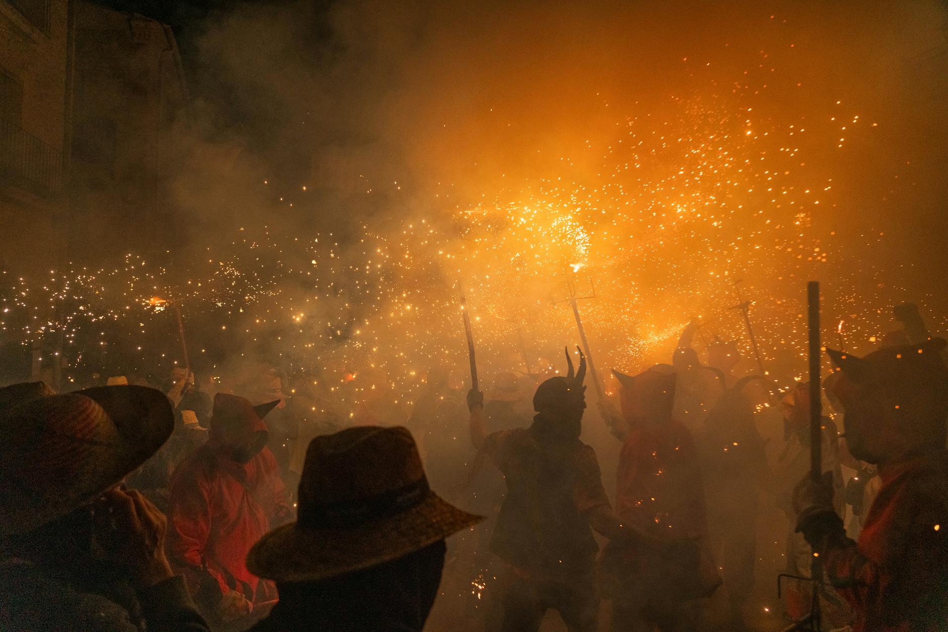Participants in fiery costumes with sparklers at a night festival in Les Borges Blanques, Cataluña.