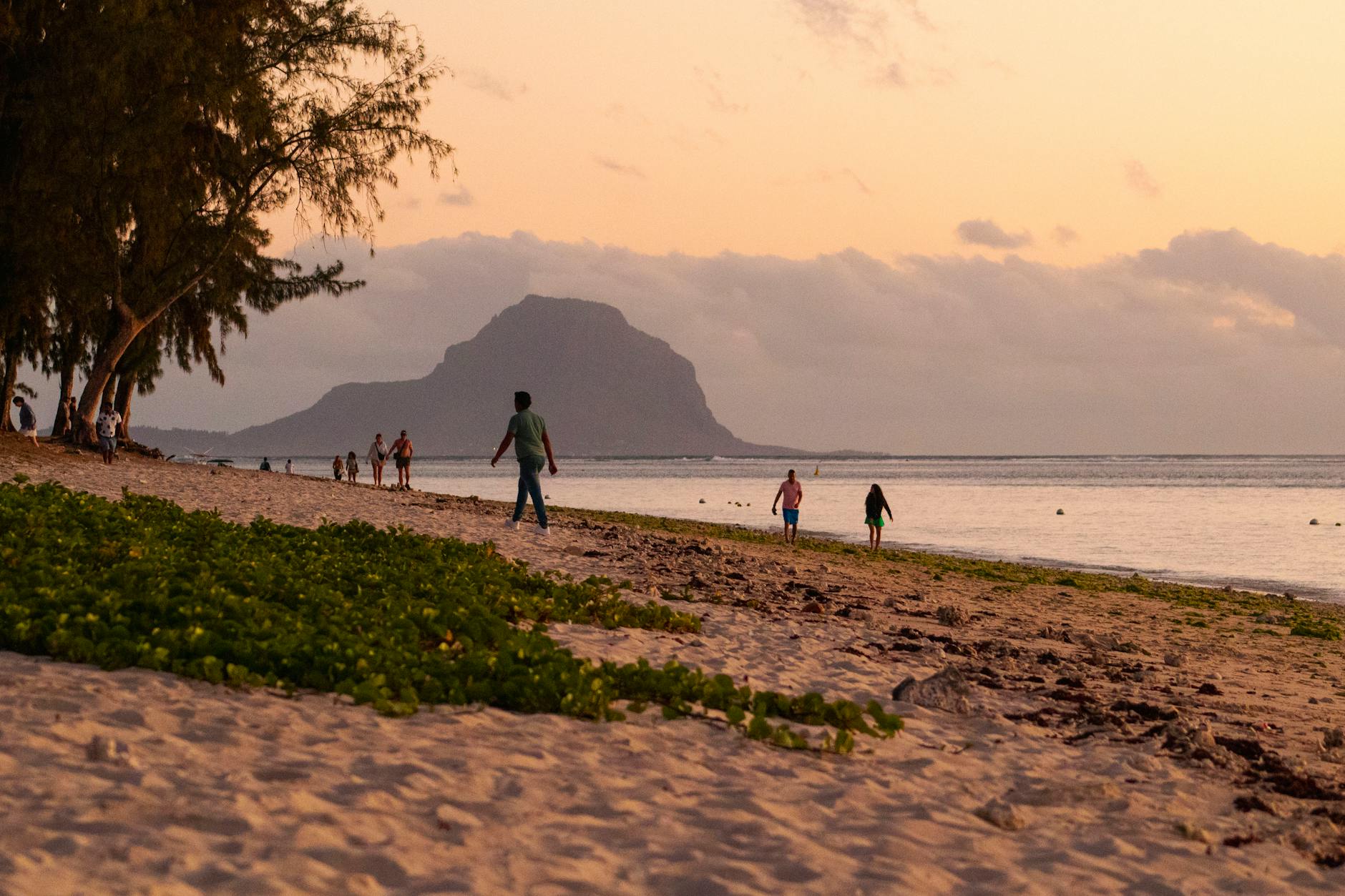 Experience a serene sunset at Flic en Flac Beach, Mauritius with Le Morne Brabant in the background.