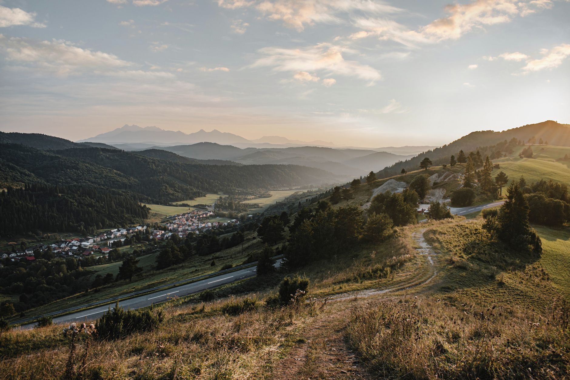 Breathtaking sunrise over Veľký Lipník village with rolling hills and misty mountains.