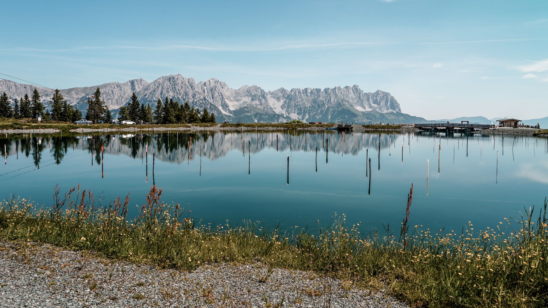 Idyllic summer scene of Wilder Kaiser reflected in a serene lake in Ellmau, Austria.