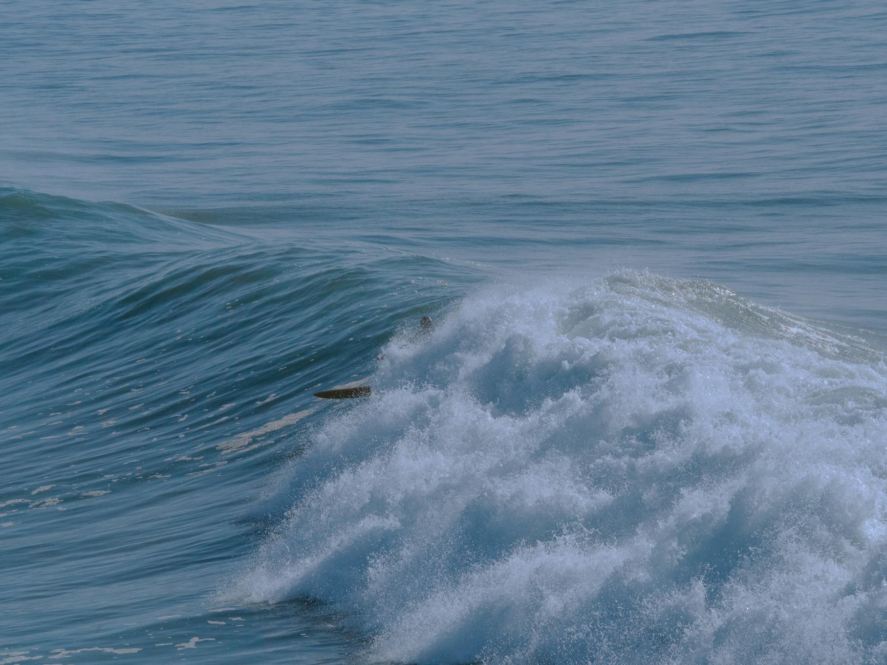 Dynamic ocean wave crashing at Taghazout's coast, showcasing nature's power.